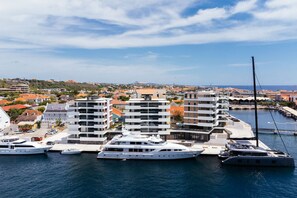 A marina with modern buildings and yachts docked. - NEW Harbour Nine at The Wharf Urban Elegance (Willemstad)