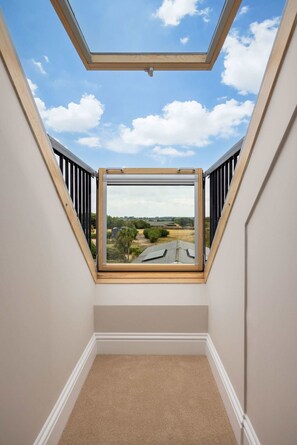 A room with a skylight window offering a view of a landscape. - Spacious Sidlesham Country Home Near Witterings (Chichester)