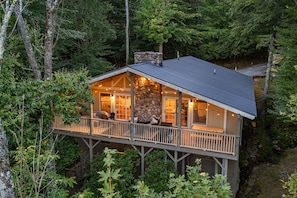Eine Hütte mit Balkon, Kamin aus Stein und mehreren Fenstern.