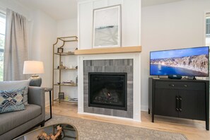 A living room with a fireplace, a television, and a sofa. - 2BR Saluda Townhome Elevator Free Tix (Saluda)