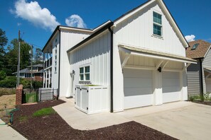 A two-story residential building with a garage and a covered entryway. - 2BR Saluda Townhome Elevator Free Tix (Saluda)