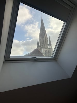 A skylight window with a view of a church tower. - Le Grenier Chic Duplex Cosy Dans le Vieux Arras (Arras)