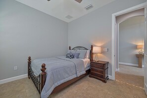 A bedroom with a bed, bedside tables, and a nightstand. - Sunny Lakeview Pool & Spa Retreat in South Fort Myers (Fort Myers)