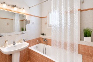 Ein Badezimmer mit einer Badewanne, einem Waschbecken und einer Duschvorhang.