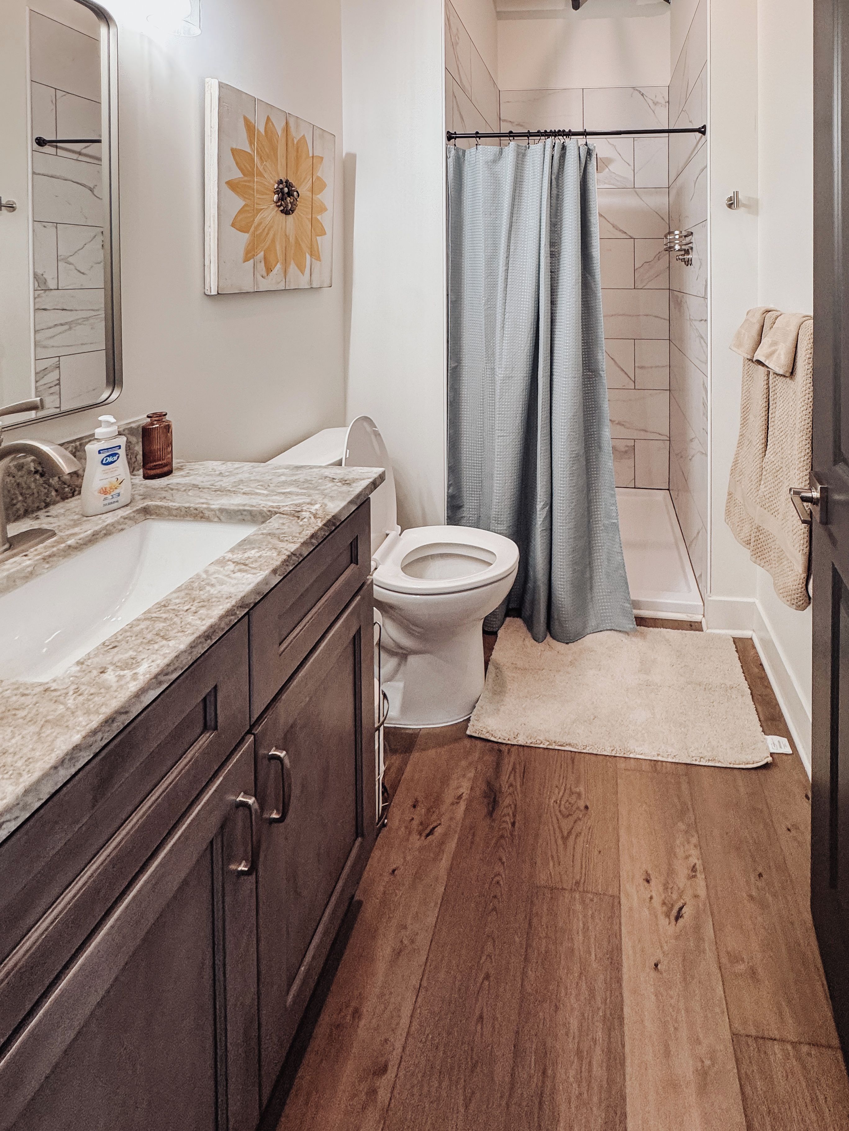 Un baño con inodoro, lavabo y zona de ducha.
