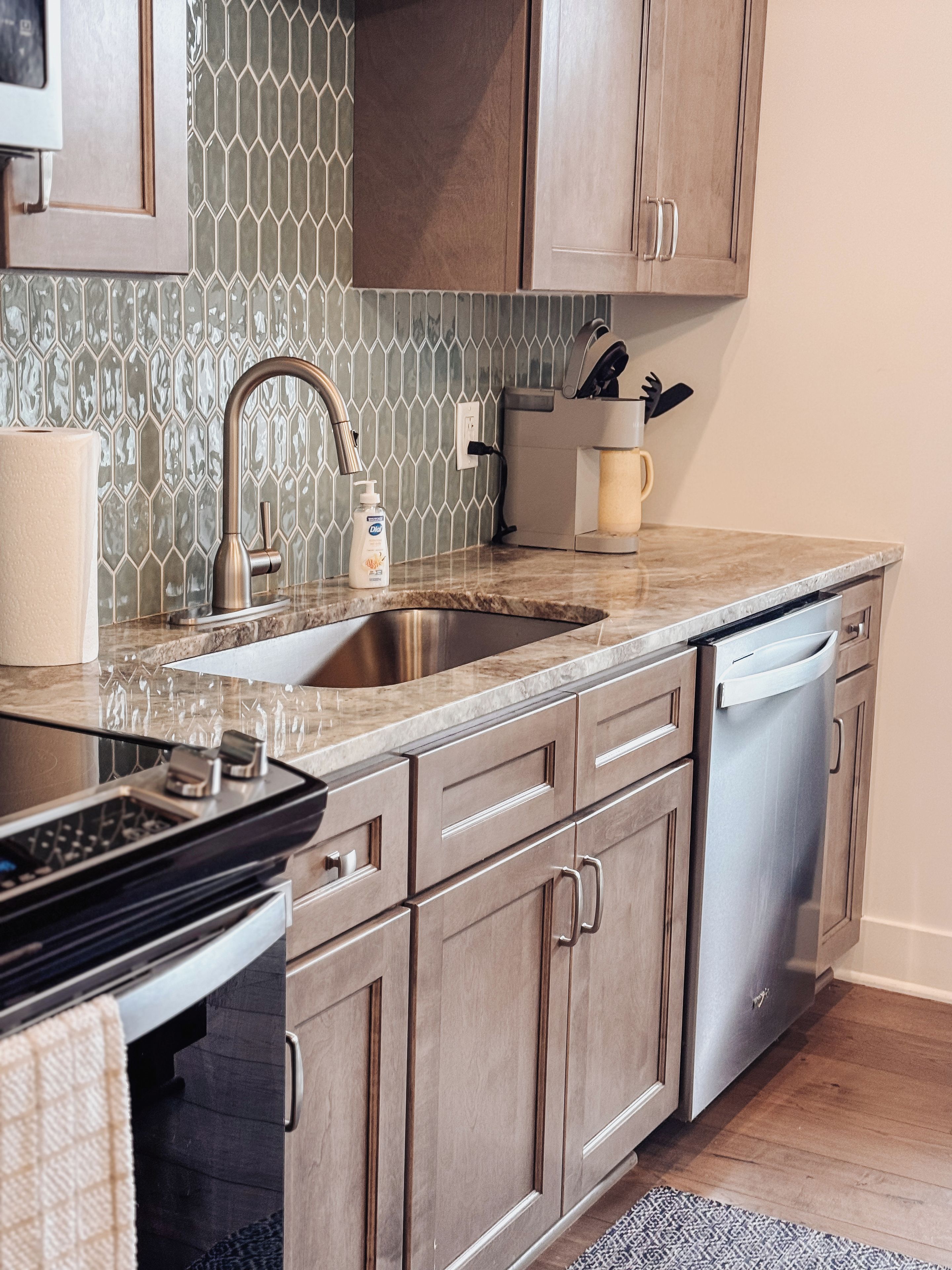 A kitchen with a double sink, stainless steel appliances, and wooden cabinets.
