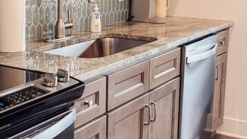 A kitchen with a double sink, stainless steel appliances, and wooden cabinets.