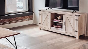 Una stanza con un armadio in legno, una televisione, una finestra e un tappeto decorato.