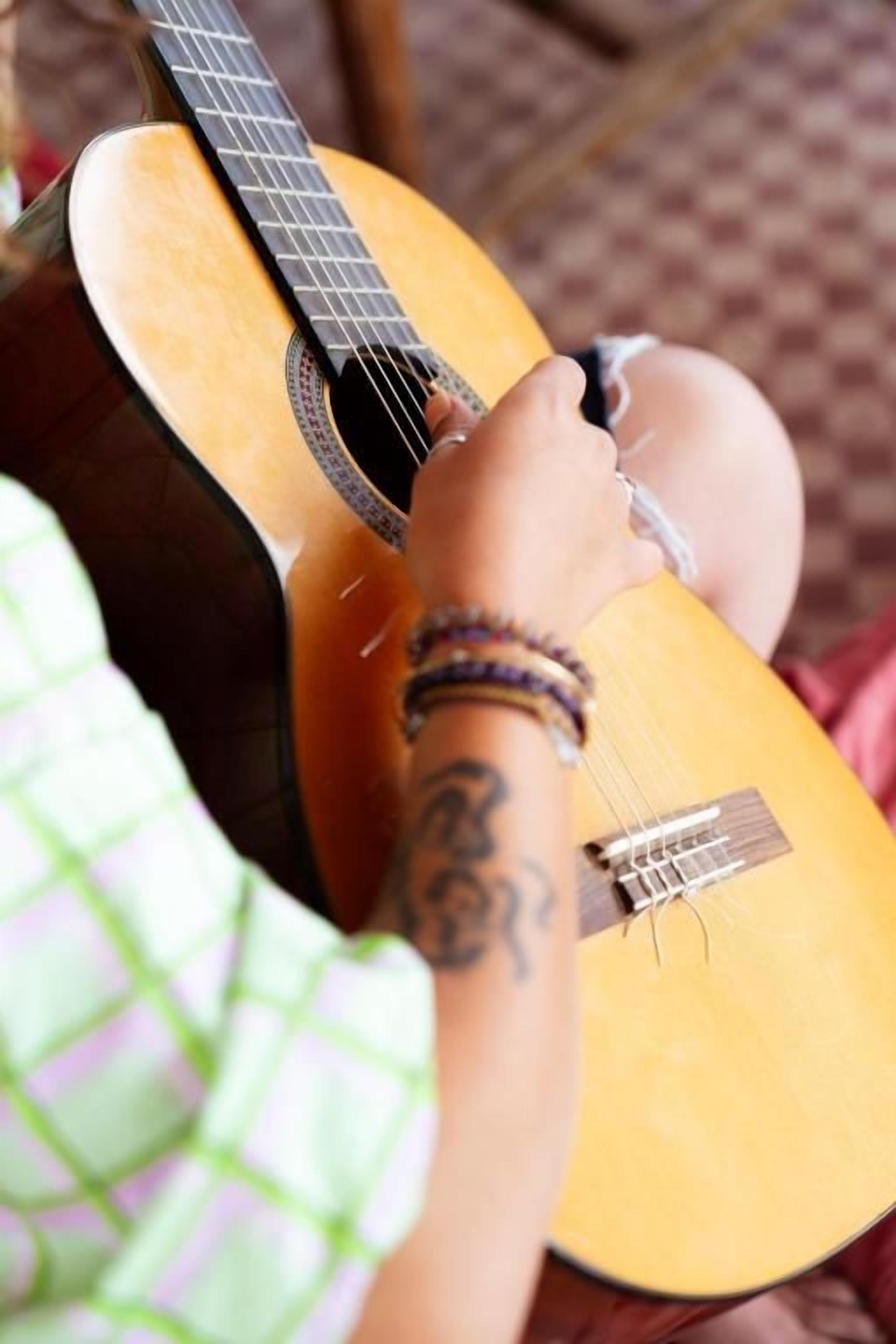 Una persona tocando una guitarra acústica.