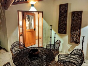 A room with a round table, four chairs, a wooden door, and two wall-mounted decorative panels. - Ocean View | Rooftop Pool | Walk to Marina/Gonzo (La Playa)