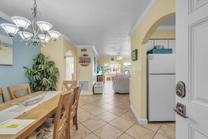 Une cuisine spacieuse avec un coin repas, un réfrigérateur et un ventilateur de plafond.