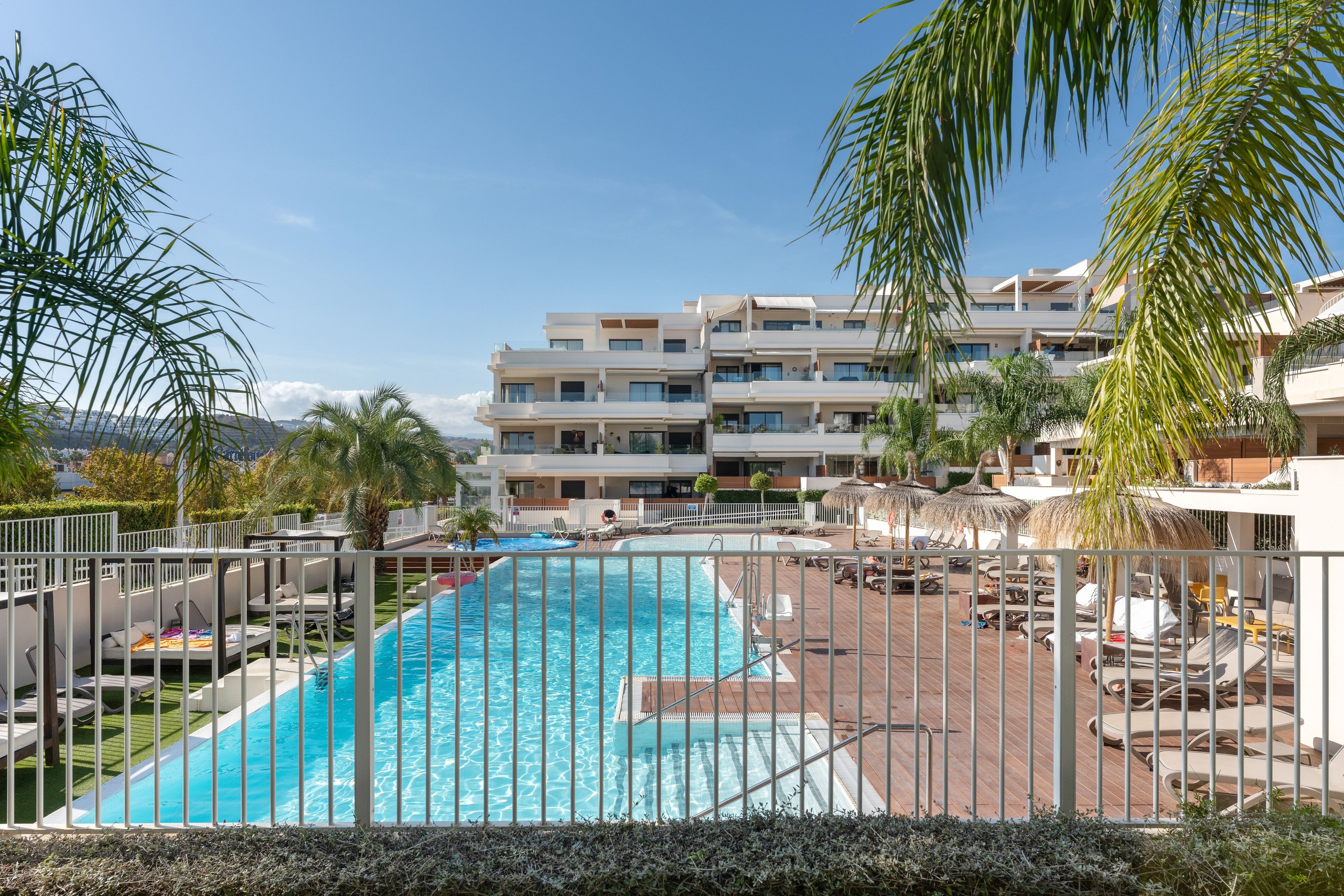 A swimming pool with a view of a multi-story building in the background.