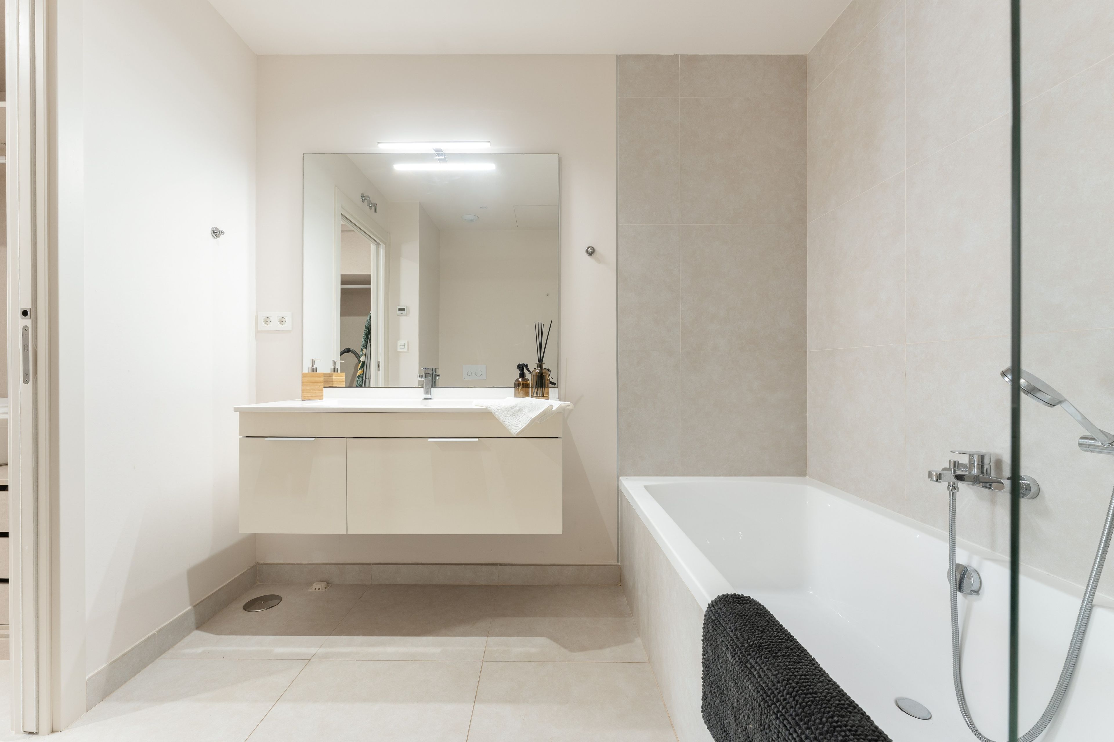 Un baño moderno con bañera, lavabo con espejo y zona de ducha.