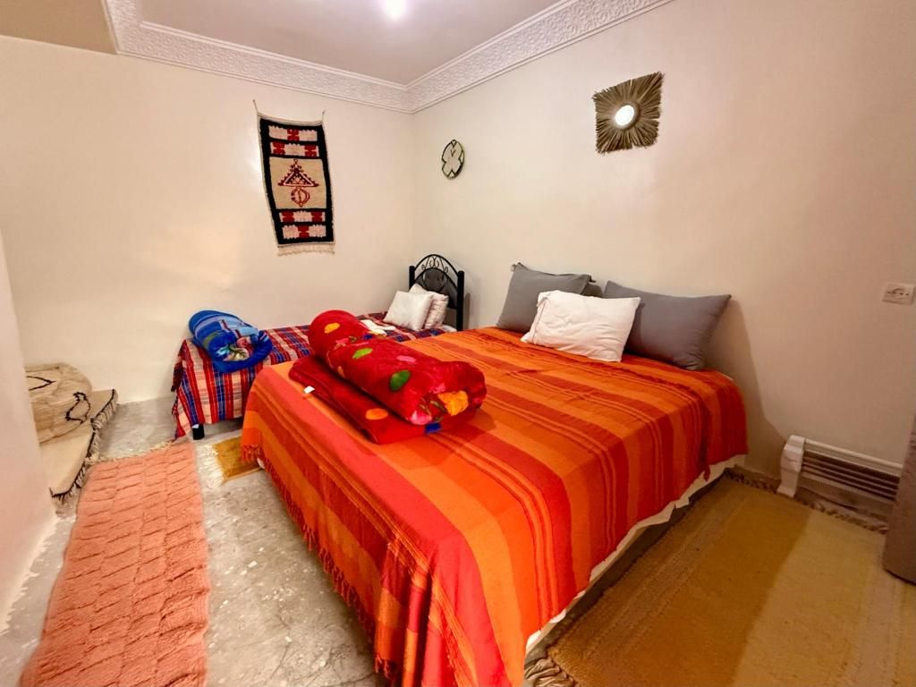 Ein Schlafzimmer mit einem Bett, Kissen, einem Teppich und einer Wanddekoration.