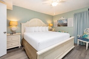 A bedroom with a bed, bedside tables, a chair, and a ceiling fan. - Phoenix East 308 1 Bedroom Condo (Orange Beach)