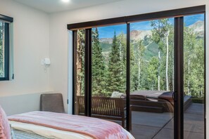 A bedroom with a large sliding glass door leading to a balcony with a mountain view. - Pine And Peak 4 Bedroom Home (Telluride)