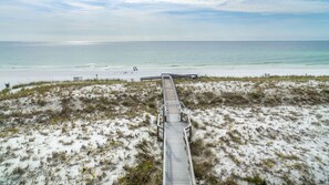 A beach with a wooden boardwalk leading to the shore. - Destin On The Gulf 204 2 Bedroom Condo (Destin)