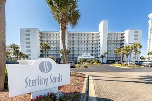 Ein mehrstöckiges Hotel mit einem auffälligen Schild, auf dem 'Sterling Sands' steht.