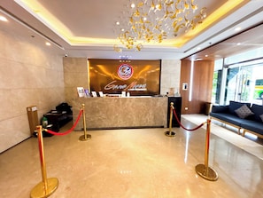 A Grand Marina Luxury Residences reception area with a marble floor, a reception desk, and a seating area with a sofa. - Grand Marina Residences (Paranaque)
