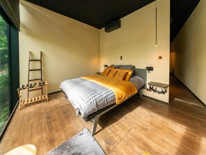 Ein modernes Schlafzimmer mit einem Bett, Holzboden und einem Fenster.