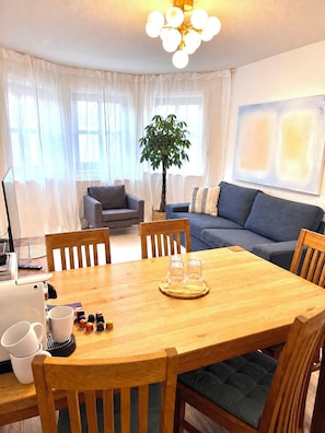 A dining area with a wooden table, chairs, and a plant.