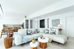 Uma sala de estar moderna com sofá, mesa de centro e mesa lateral.