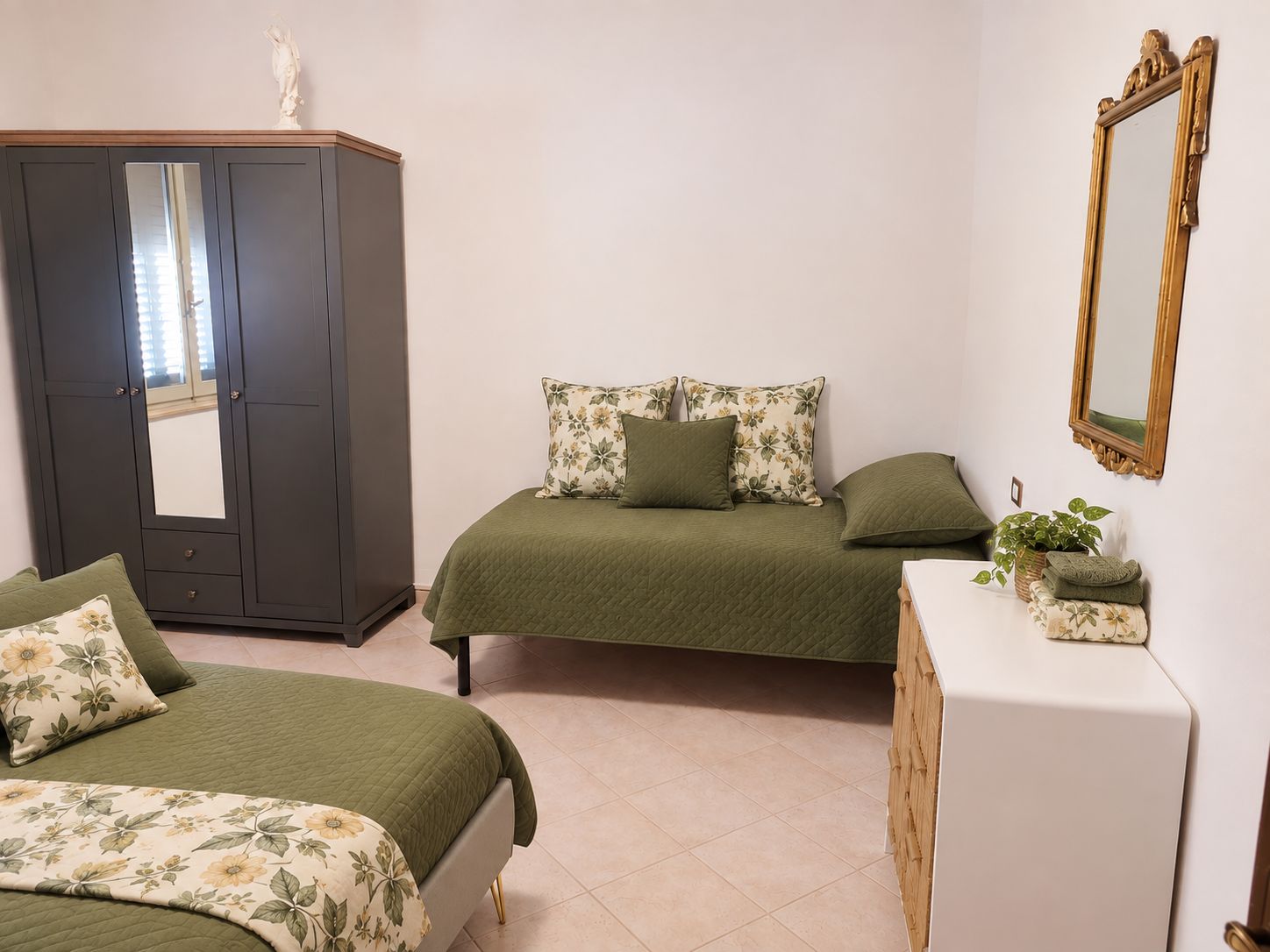 Una camera da letto con due letti, una cassettiera, uno specchio e un armadio.