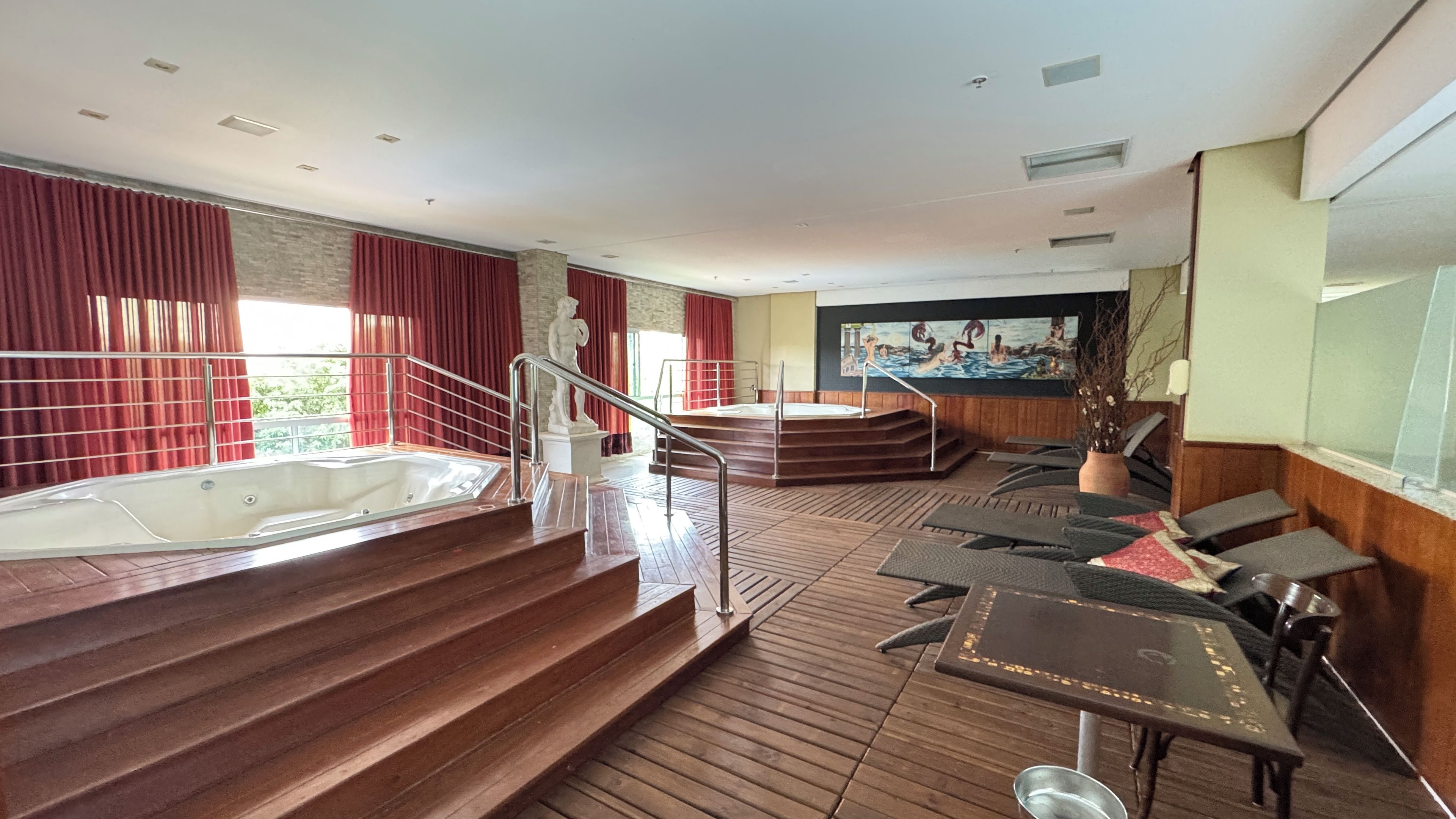 A spa area with a hot tub, wooden steps, and lounge chairs.