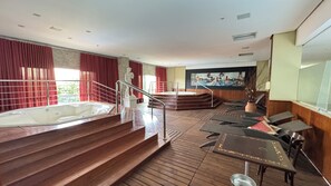 A spa area with a hot tub, wooden steps, and lounge chairs.
