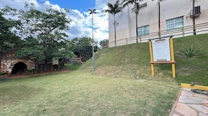 A grassy area with a stone archway labeled 'LAB,' a playground, and a building with a signboard.