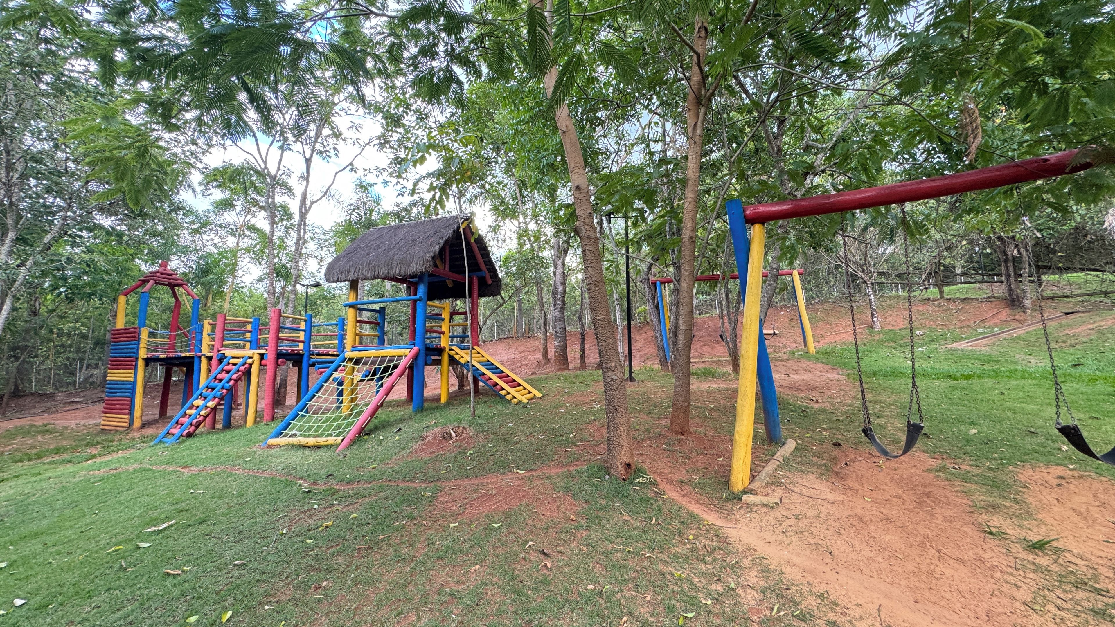 Une aire de jeux avec une structure d’escalade et des balançoires.