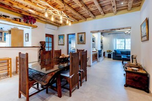 A dining area with a wooden table and chairs, a kitchen area with a stove, and a living room with a sofa and a coffee table.