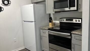 Une cuisine équipée d’un réfrigérateur, d’un four à micro-ondes, d’une cuisinière, d’un four et de placards.