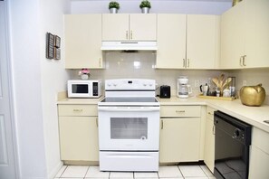 A kitchen with a stove, microwave, oven, and dishwasher.