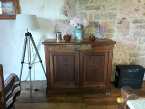 Ein Holzkabinett mit einer Lampe, einem Stativ und einer Vase mit Blumen.