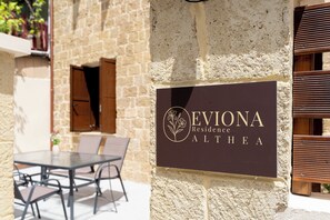 Ein Schild mit der Aufschrift 'Eviola Residence Althea' an einer strukturierten Wand.