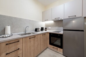 Eine moderne Küche mit einem Edelstahl-Kühlschrank, einem Geschirrspüler und einer Kaffeemaschine.