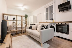 A modern living room with a sofa, a television, and a bookshelf. - Newly renovated in the heart of Madrid (Madrid)