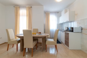Una cocina moderna con armarios blancos, microondas y hervidor.