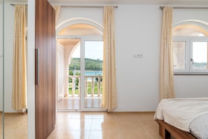 Ein Schlafzimmer mit Balkon, einem Bett und Blick auf eine grüne Landschaft.