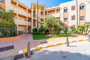 A multi-story residential building with balconies, a central staircase, and a landscaped courtyard with palm trees. - Cubo's Opalo de Riviera Apartment / communal pool / communal gym / air conditioning / terrace (Mijas Costa)