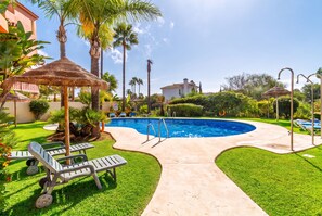 A swimming pool with a surrounding deck, lounge chairs, and palm trees. - Cubo's Opalo de Riviera Apartment / communal pool / communal gym / air conditioning / terrace (Mijas Costa)