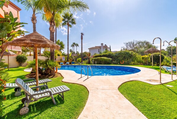 A swimming pool with a surrounding deck, lounge chairs, and palm trees. - Cubo's Opalo de Riviera Apartment / communal pool / communal gym / air conditioning / terrace (Mijas Costa)