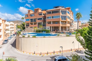 A multi-story hotel with a swimming pool, a parking area, and a view of the surrounding landscape. - Cubo's Opalo de Riviera Apartment / communal pool / communal gym / air conditioning / terrace (Mijas Costa)