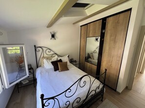 A bedroom with a bed, bedside table, and a wardrobe with a mirror. - A night under a starry sky in the peaceful countryside at the foot of the mountains. (Castellet-lès-Sausses)