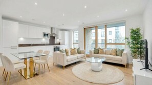 Un apartament modern amb cuina, zona de menjador i saló.