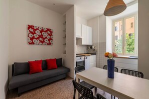 Ein gemütlicher Wohnbereich mit einer Couch, Esstisch und Küchenzeile.
