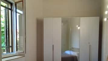 Una camera da letto con un letto, uno specchio grande e una finestra.