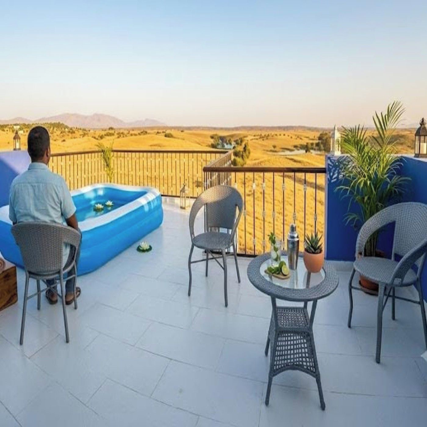 Una terraza con piscina, sillas y vistas al desierto.