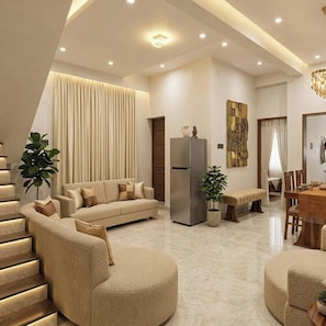 A modern living room with a sofa, a dining area, and a kitchen.